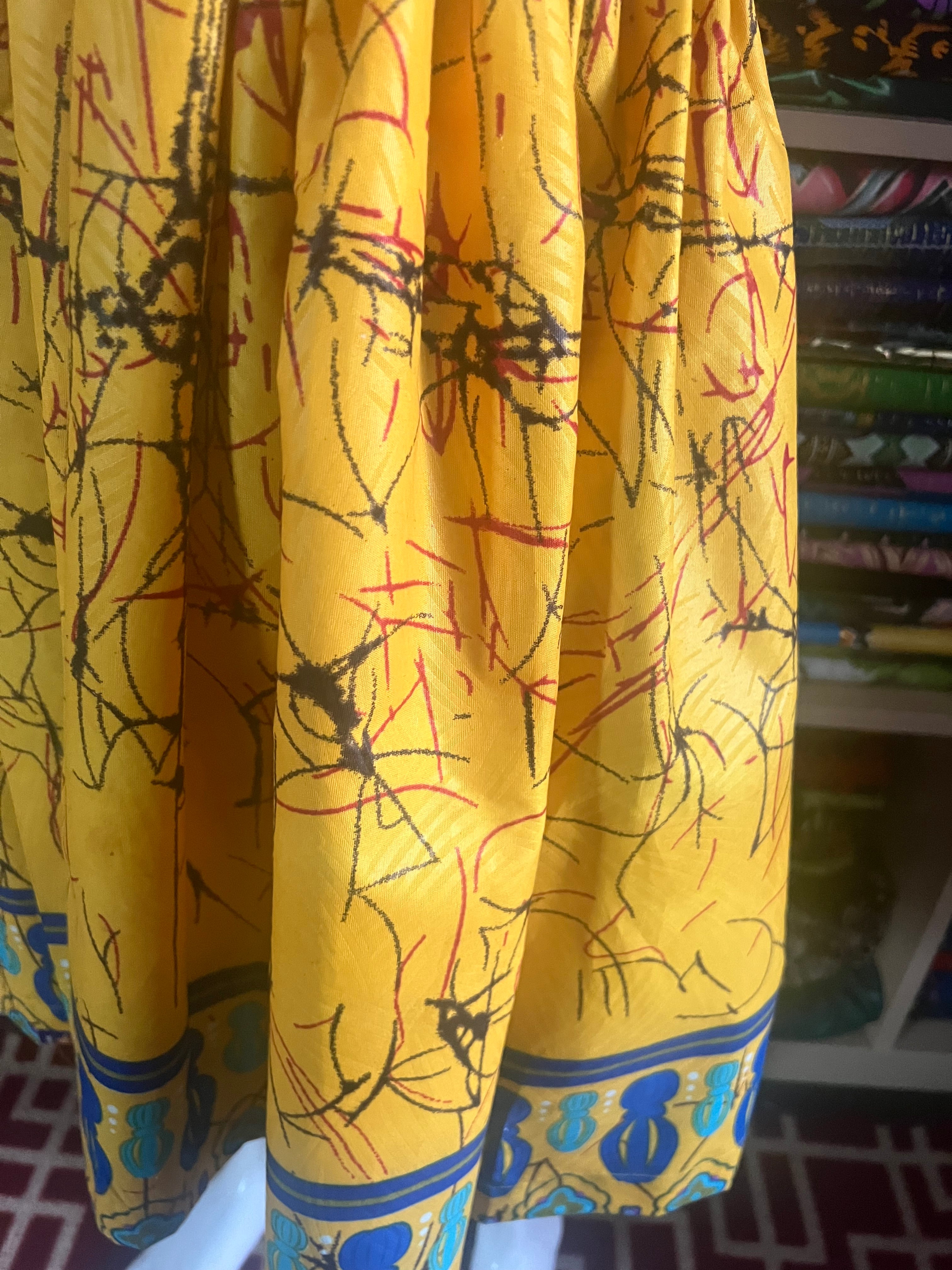 A children's dress designed for ages 7 to 10, featuring coordinating taffeta and Ankara fabric, finished with a stylish knot  at the back.