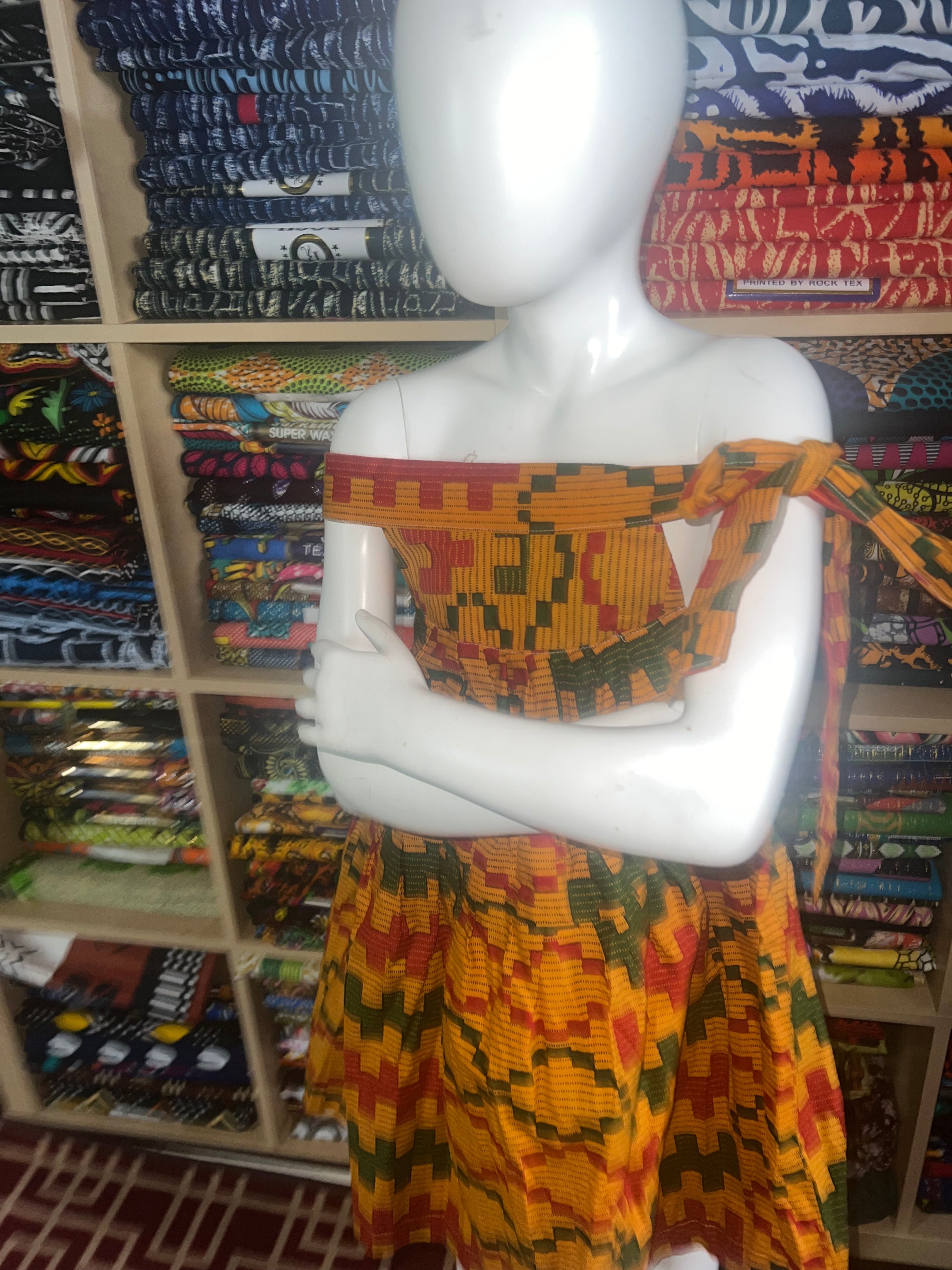 african kaba for kids crafted from vibrant ankara kente fabric ,featuring an open neckline that culminates in a delicate tie at the shoulder