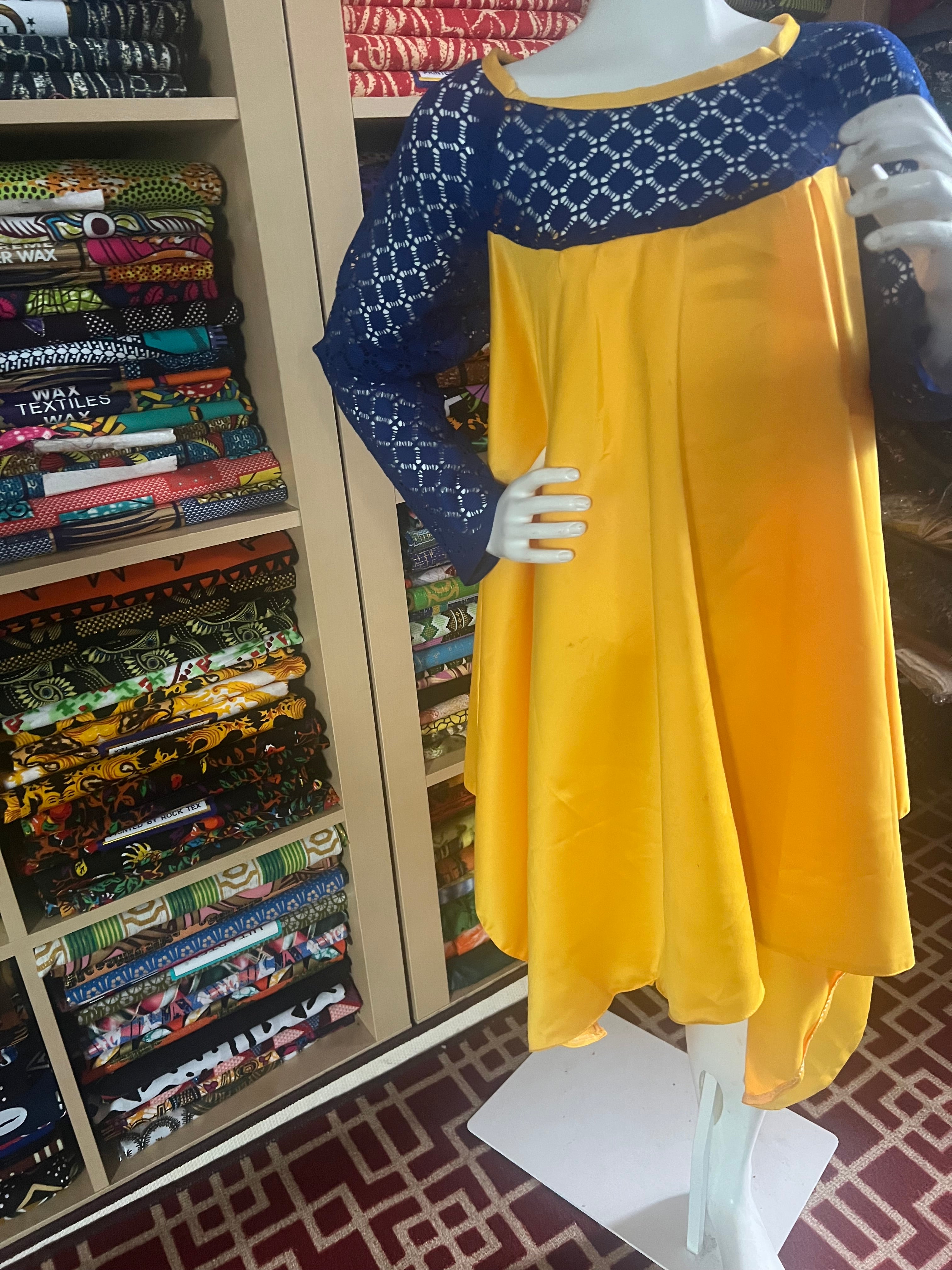 this beautiful Kaba for children is sewn with  yellow  duchess Satine mixed with a blue lace creating a vibrant and eye-catching design.