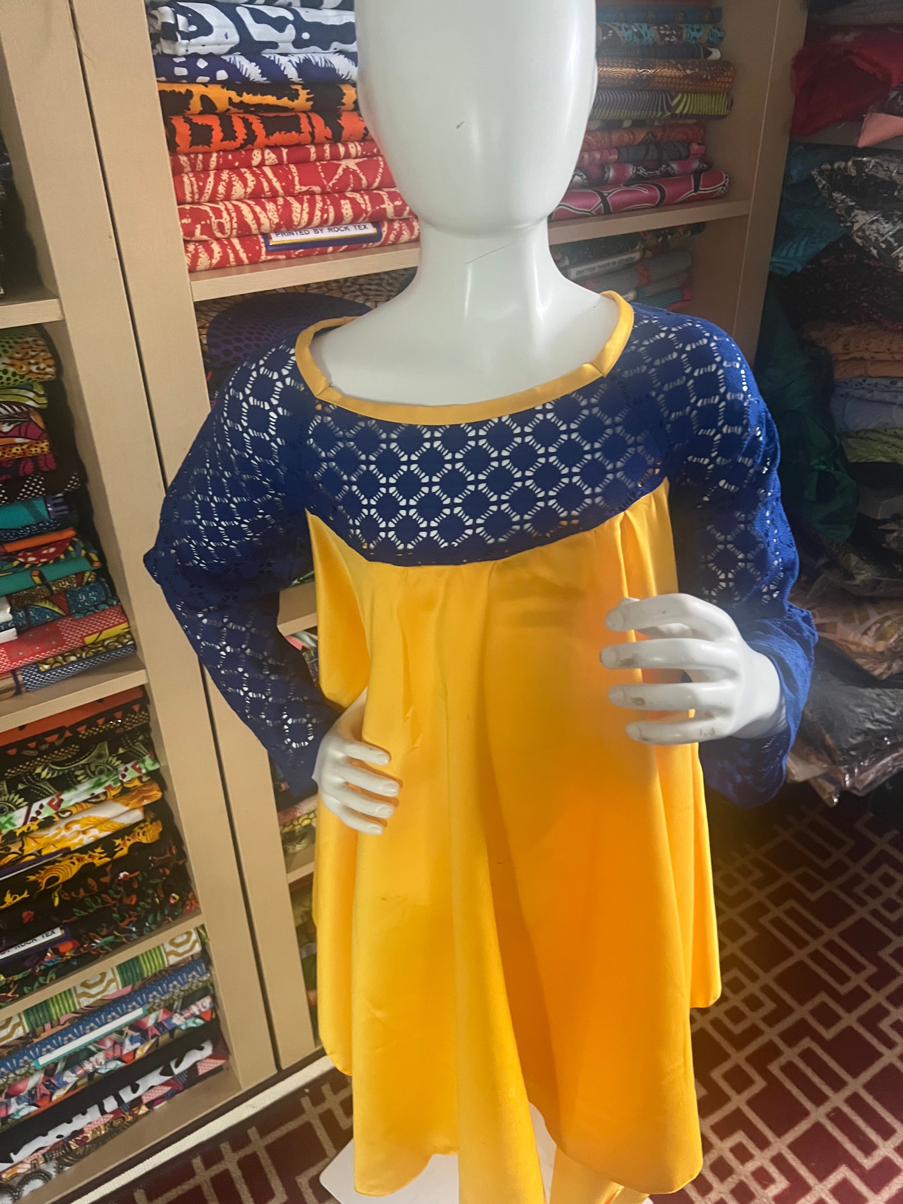 this beautiful Kaba for children is sewn with  yellow  duchess Satine mixed with a blue lace creating a vibrant and eye-catching design.