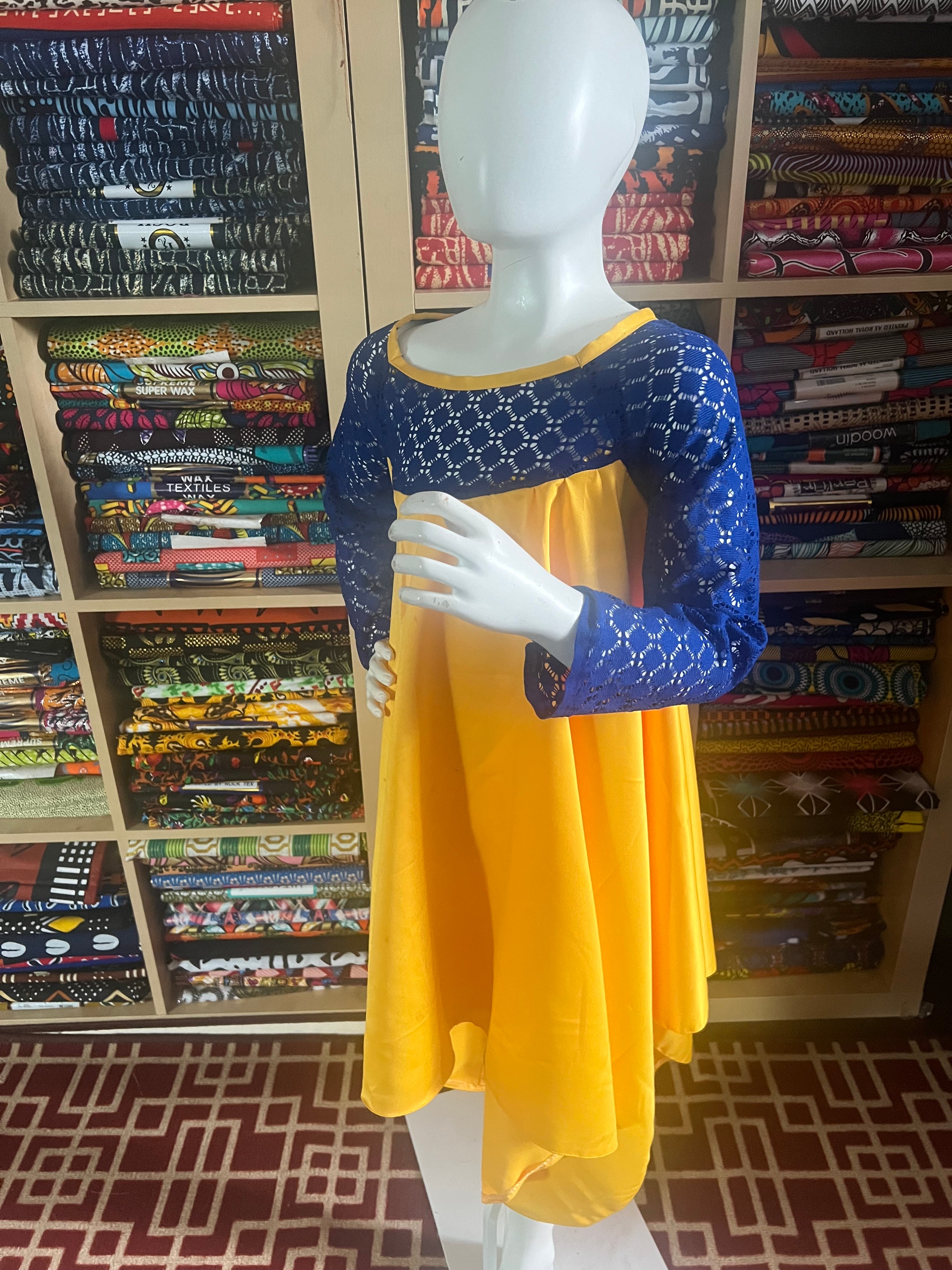 this beautiful Kaba for children is sewn with  yellow  duchess Satine mixed with a blue lace creating a vibrant and eye-catching design.